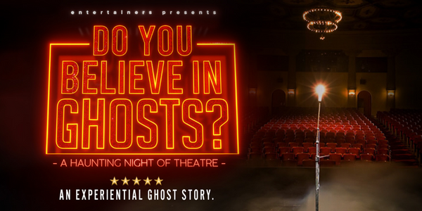 An empty theatre with a single light on a stand, a ghost light, on the stage.