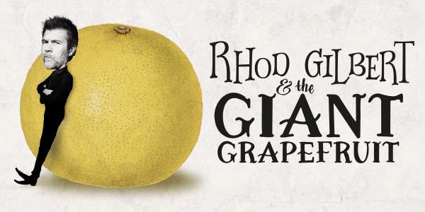 Rhod Gilbert leaning on a giant grapefruit