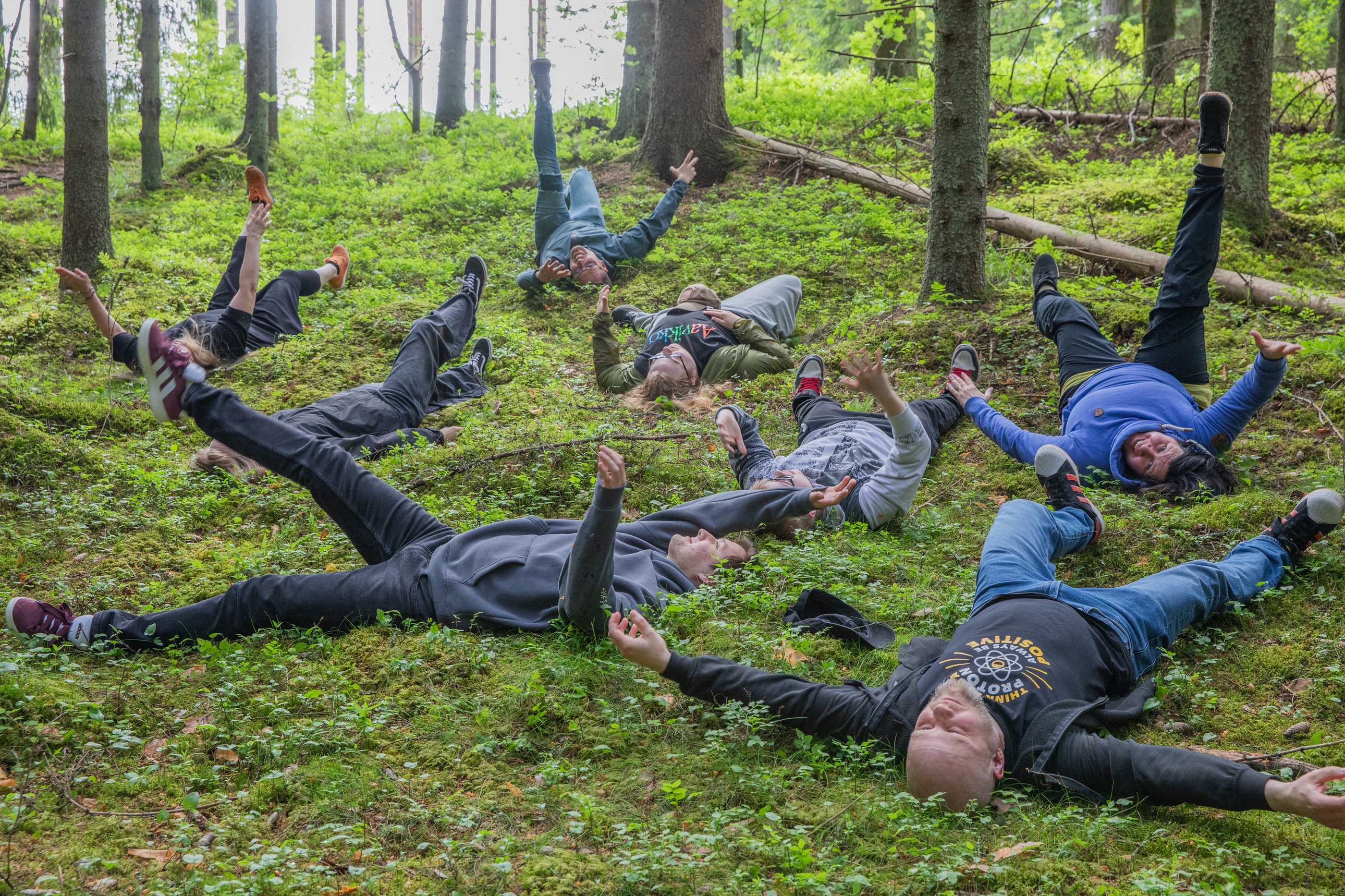 Valokuva. Ihmisiä makaamassa syksyisessä luonnossa.