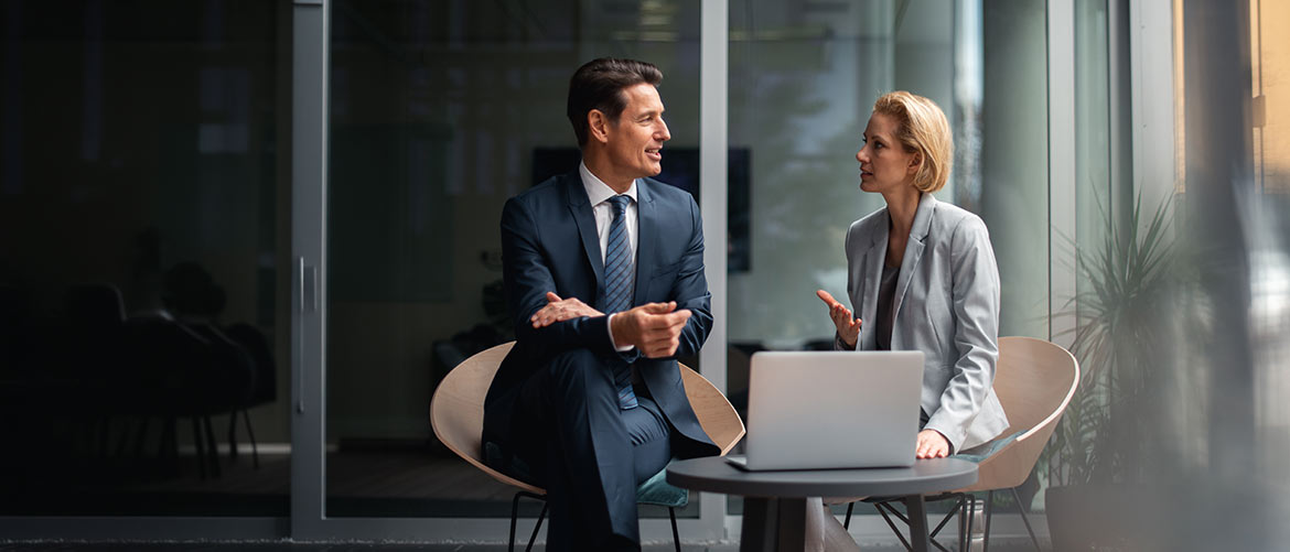 Zwei Personen im Business-Meeting mit Laptop, Beratung zu Arbeitsrecht & Wettbewerb, modernes Büro, Rechtsanwalt Gespräch, Unternehmensrecht, Compliance.