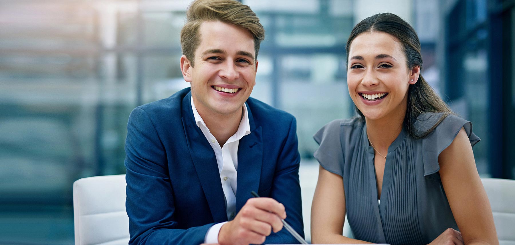 Zwei Personen im Business‑Setting, Besprechung an einem Tisch, moderne Büroatmosphäre, Zusammenarbeit, professionelle Beratung.