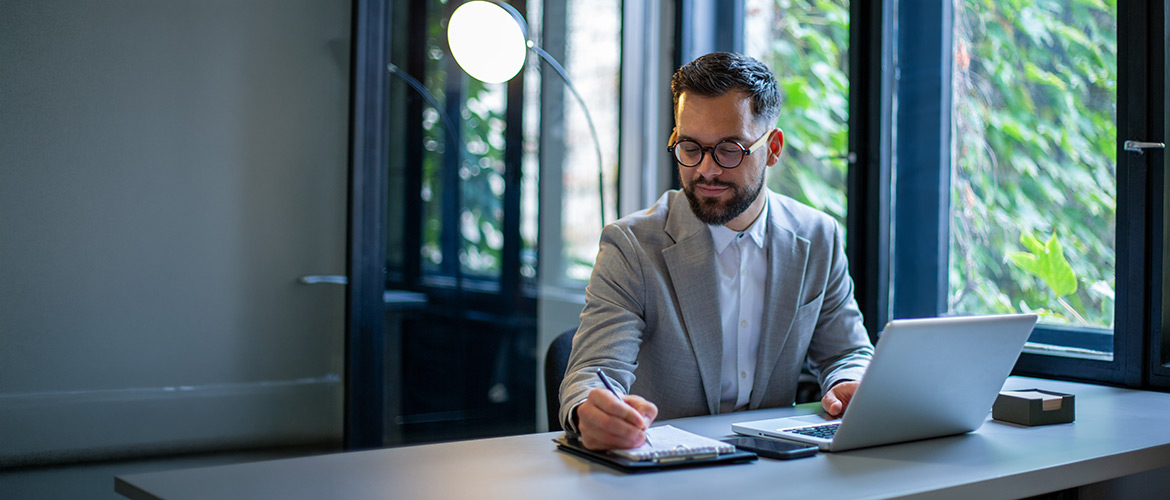 Fotorealistische Abbildung einer notariellen Praxis: Person am Schreibtisch mit Laptop und Unterlagen, modernes Büro, Beratung, Vertragsprüfung, Notar, Recht, Vertrauen.