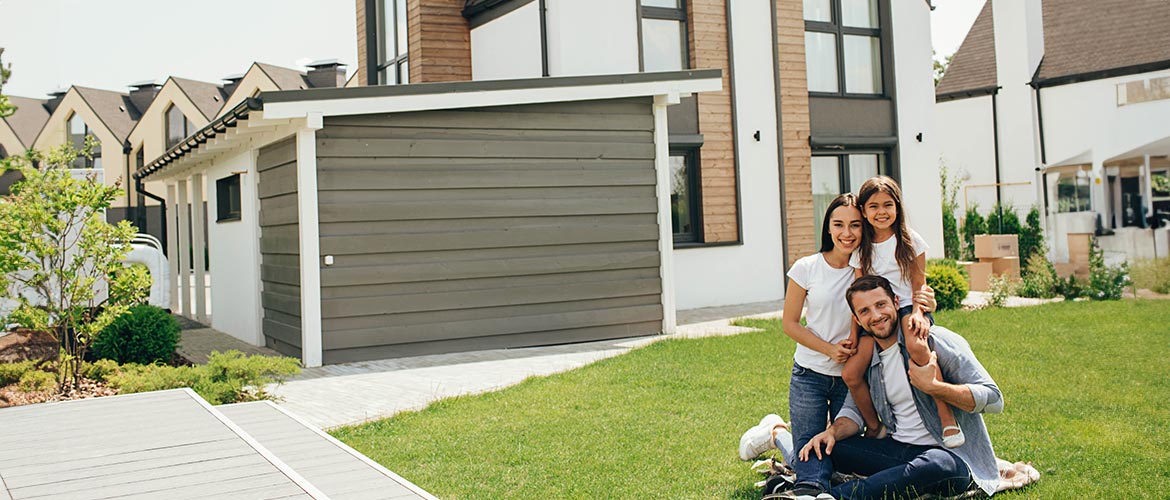 Glückliche Familie sitzt vor den Eigenheim  – Symbolbild für rechtssichere Immobilienübertragung, Beratung und notarielle Begleitung bei Hauskauf oder Schenkung. Passend für Fortbildungen im Immobilienrecht, Familienrecht oder Notarrecht des DAI