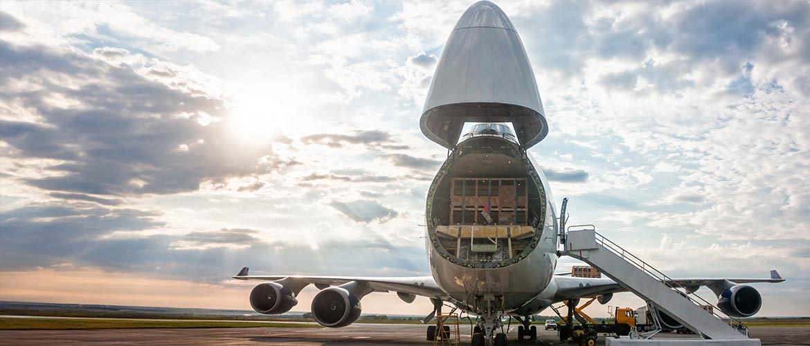 Frachtflugzeug mit geöffneter Nase beim Beladen, Luftfracht, Logistik, internationale Lieferkette, Flughafenabfertigung, Schwerlasttransport.