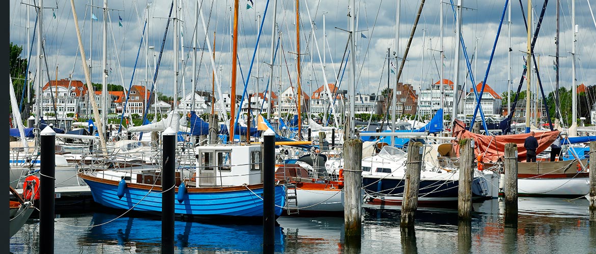 Yachthafen Travemünde mit zahlreichen Segelbooten, Masten und ruhigem Wasser; maritime Atmosphäre, bunte Boote, Küstenarchitektur, Nordsee Ostsee Hafen, DAIvent Location, Segelsport, Urlaub, Deutschland.