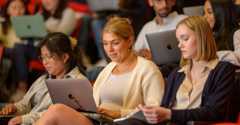 Students are on their laptop in a lecture theatre.