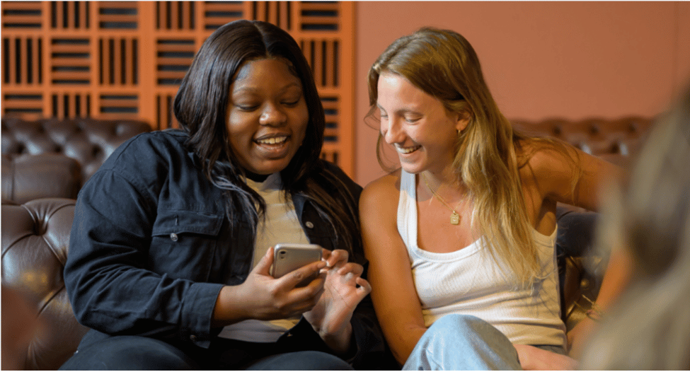 Two King's students using the Welcome to King's app on their phone.