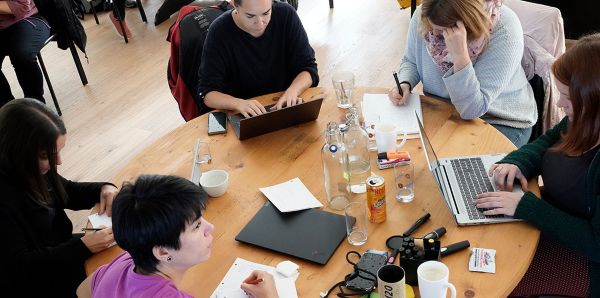 Arbeitende Menschen an einem runden Tisch