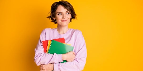 Frau mit Büchern in der Hand schaut nach rechts