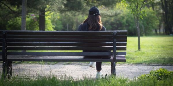 Junger Mensch auf Parkbank