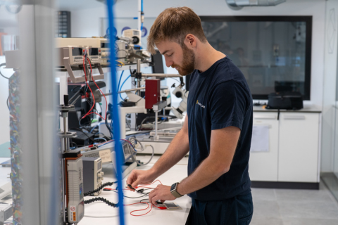 Photo of a man at a work station with scientific equipment