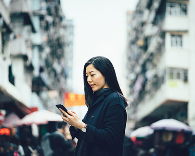 Woman looking at cell phone in the street