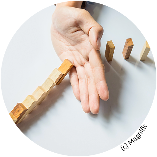 Hand, die fallende Dominosteine aufhält