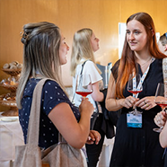 Zwei Damen, die sich beim Forum in Salzburg ein Glas wein gönnen und miteinander sprechen