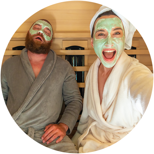 Frau mit Gesichtsmaske, die ein Selfie mit einem schlafenden Mann (auch mit Gesichtsmaske) macht