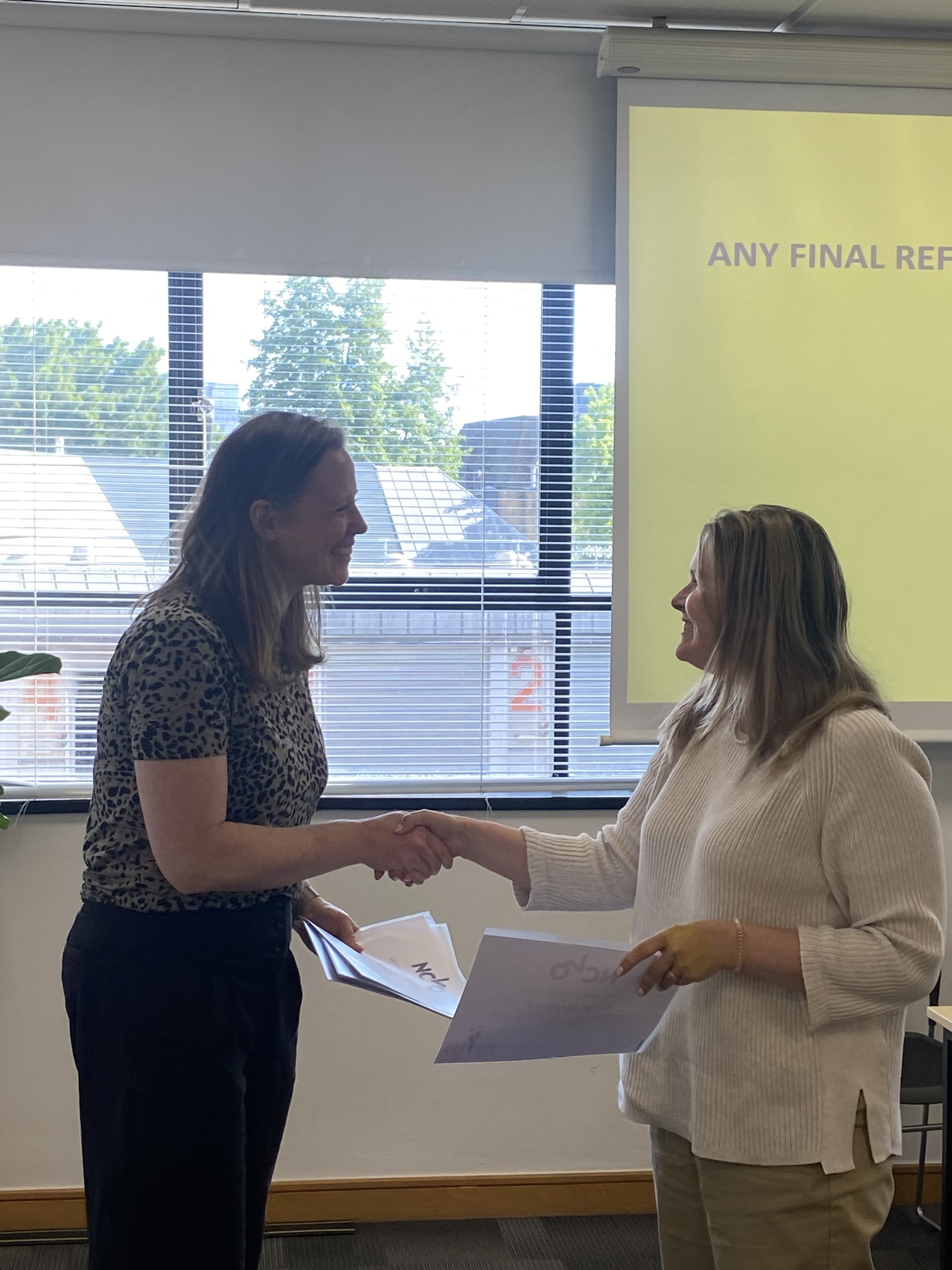 Course instructor congratulates a participant during the Leading on Purpose programme certificate presentation.