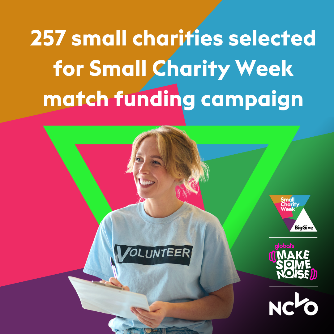 Graphic announcing that 257 small charities have been selected for the Small Charity Week match funding campaign. A smiling volunteer wearing a light blue “Volunteer” T-shirt holds a clipboard in the foreground. The background features bold geometric shapes in bright orange, blue, pink, green, and purple. Logos for Small Charity Week, Global’s Make Some Noise, and NCVO appear on the right side.