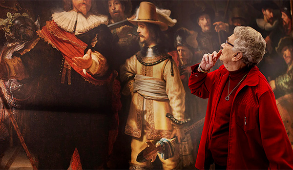 Een mevrouw met een rood jasje bekijkt doordacht De Nachtwacht van dichtbij