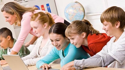 Oppilaita ja opettaja koulutunnilla.