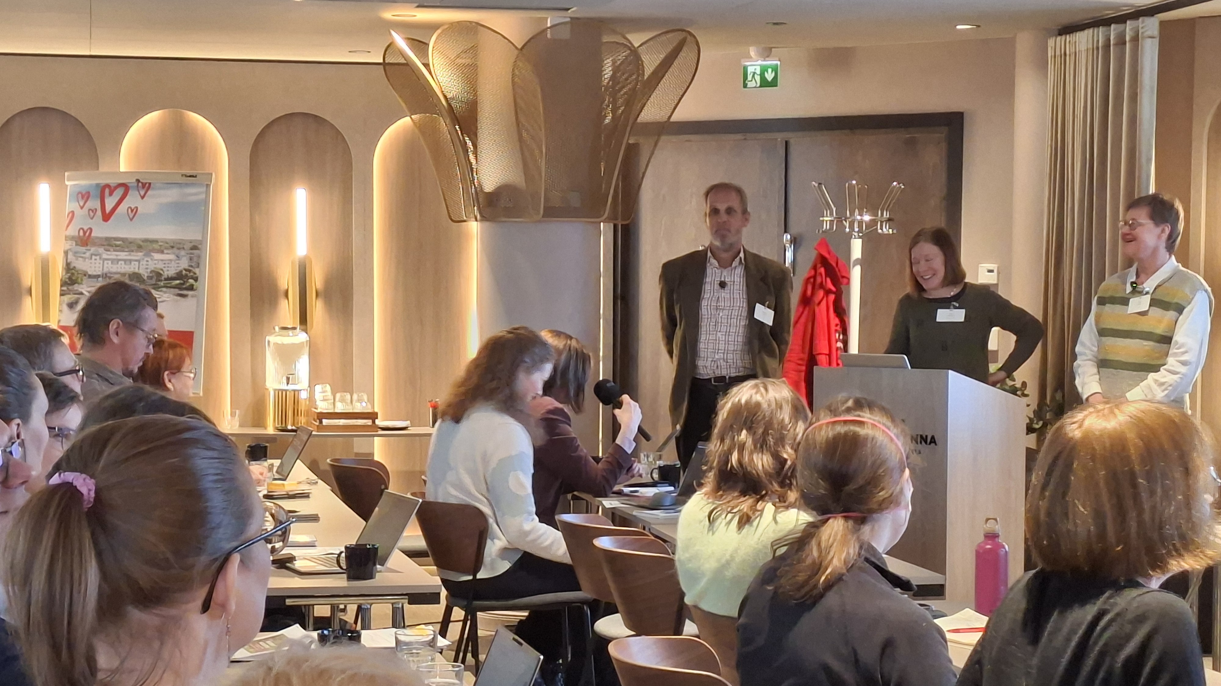 Henkilöitä istumassa ja seisomassa foorumissa.