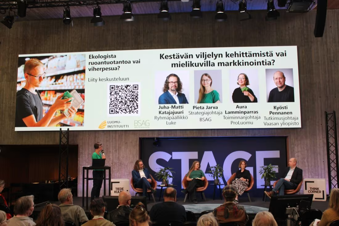 Paneelin jäsenet istumassa lavalla.