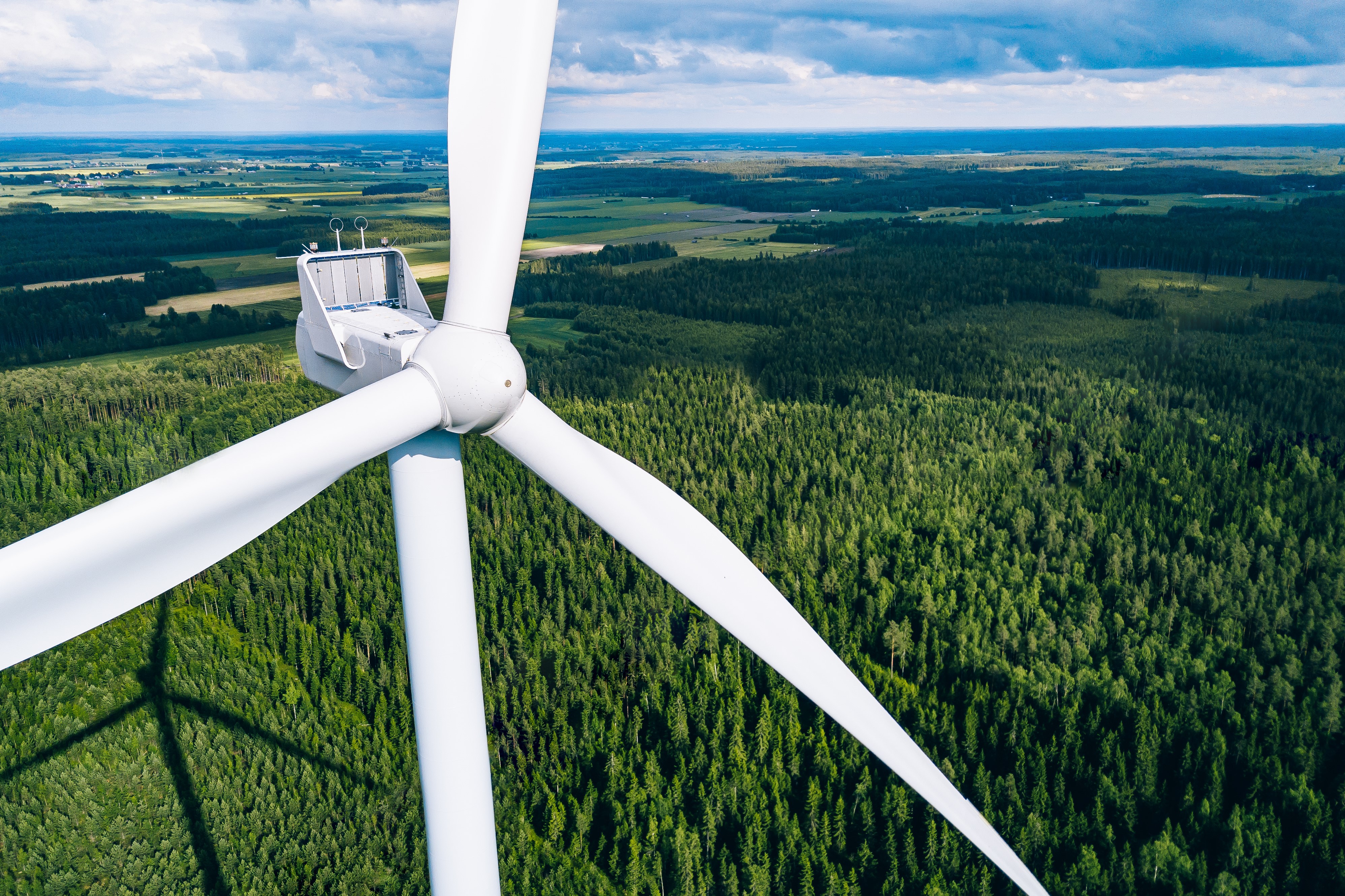 Tuulivoimala metsämaiseman edessä.