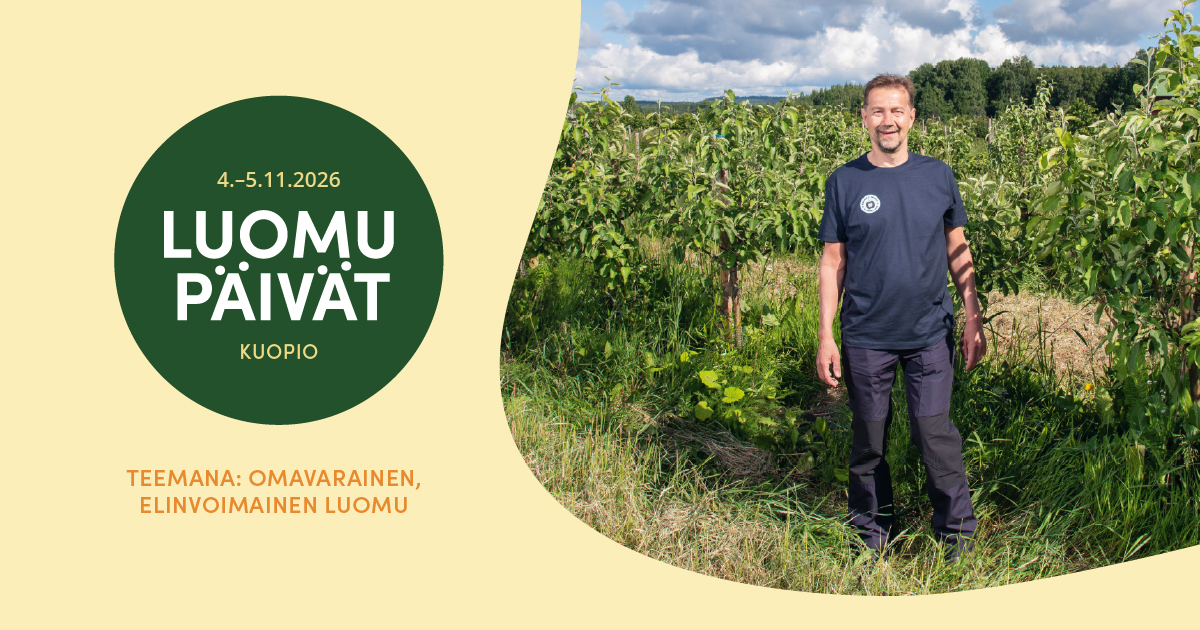 Luomupäivät banneri. Henkilö seisomassa istutusten vieressä.