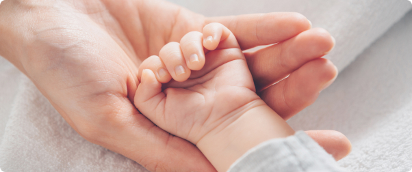 Mano de bebé reposada sobre mano de mujer