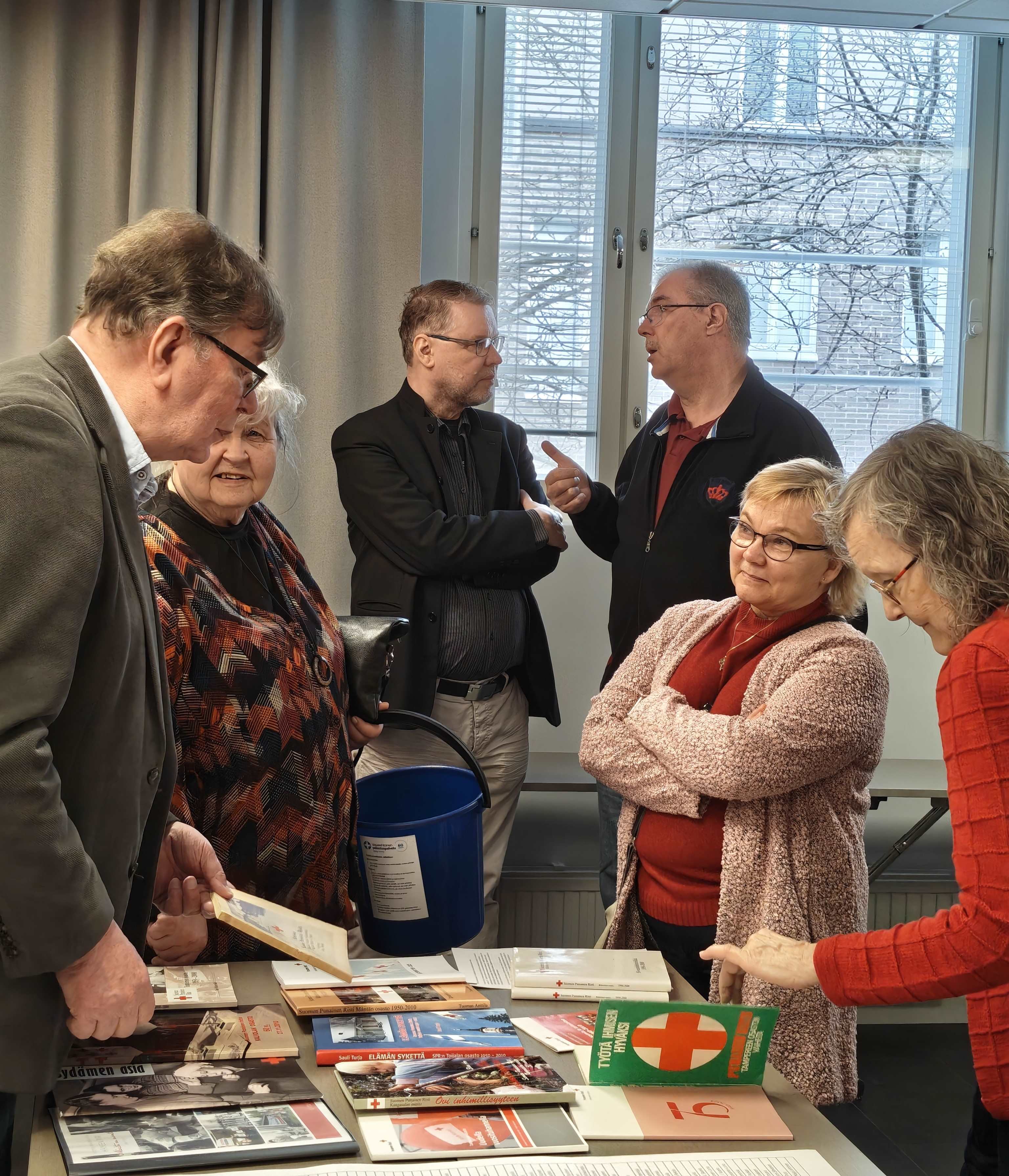 Ihmiset ovat kerääntyneet pöydän äärelle keskustelemaan