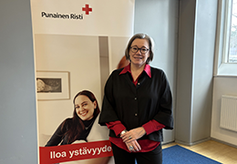 Hymyilevä henkilö seisomassa rollupin edessä.