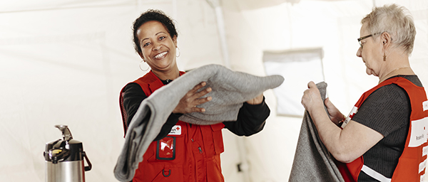 Kaksi Punaisen Ristin vapaaehtoista viikkaamassa huopia.