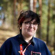 Henkilö ulkona, taustalla metsää.