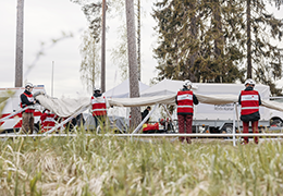 Punaisen Ristin vapaaehtoisia pystyttämässä isoa telttaa.