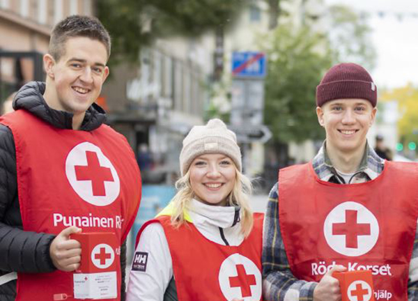 Kolme Nälkäpäivä-kerääjää seisoo rinnakkain kävelykadulla.