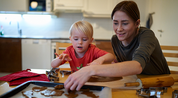 Lapsi ja aikuinen leipovat yhdessä pipareita.