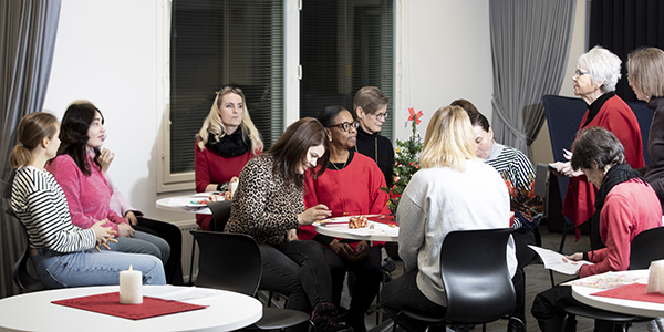 Henkilöitä istumassa pöytien äärellä.