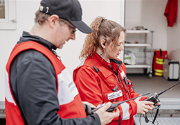 Kaksi vapaaehtoista, mies ja nainen, valmiusharjoituksessa. He pitävät radiopuhelimia kädessään.