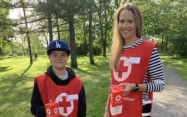 Kaksi Nälkäpäivä-kerääjää seisoo puistossa.