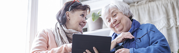 Kaksi henkilöä rinnakkain katsomassa tablettia.