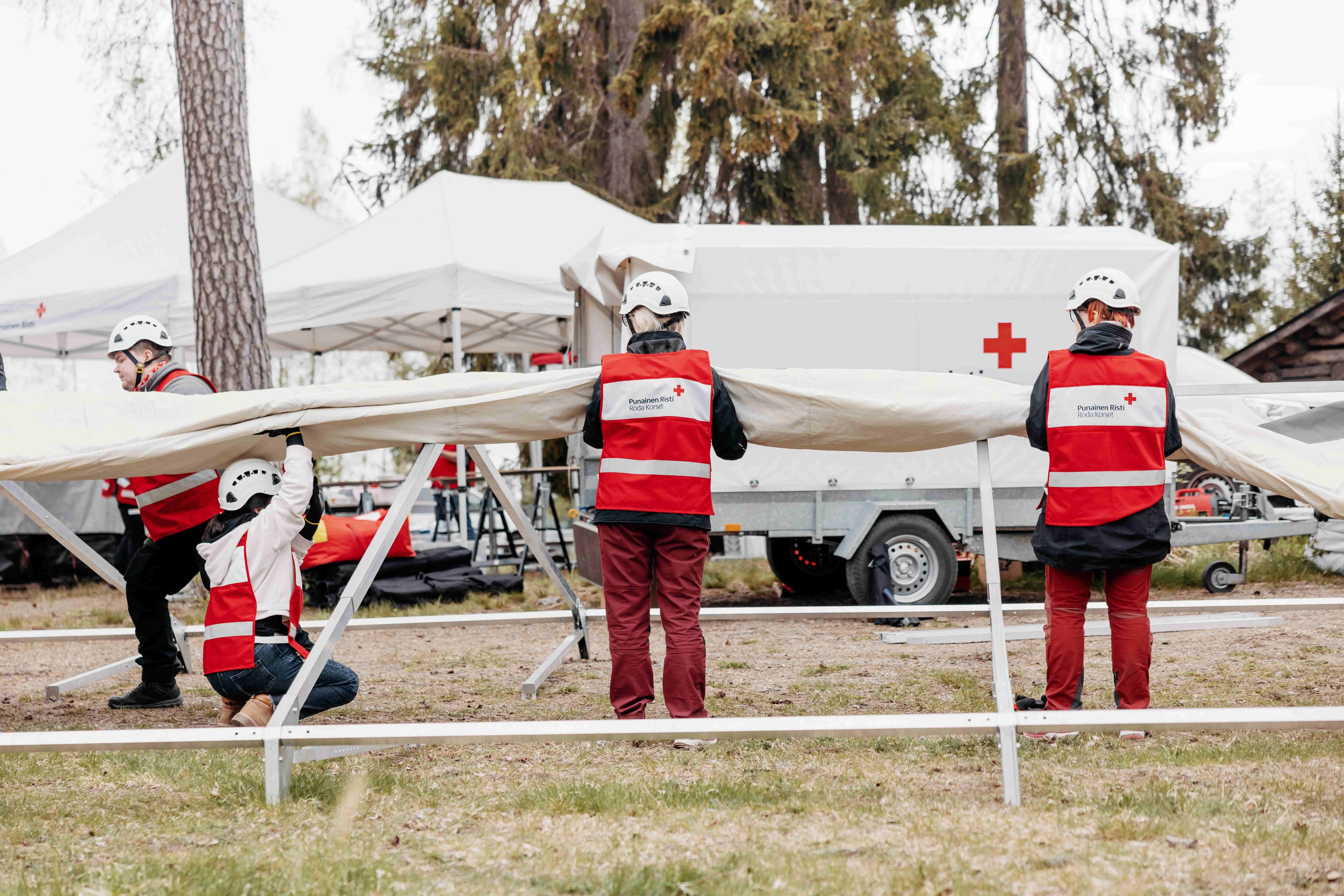 vapaaehtoiset pystyttävät telttaa