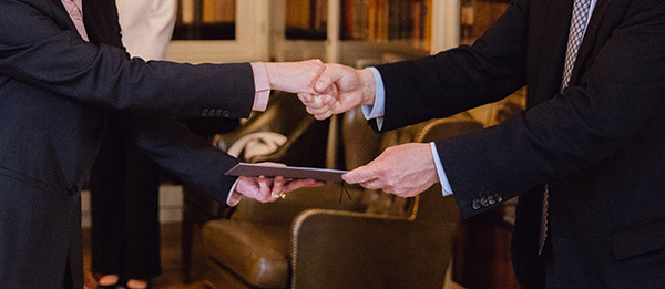 händer som överräcker och tar emot diplom