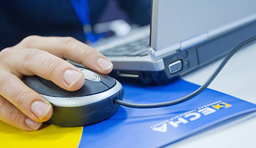 laptop, hand on the mouse and a folder with ECHA logo