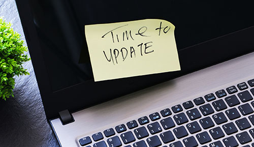 Post-it note with text "Time to update" on laptop screen