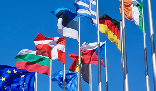 Flags of several EU countries with blue sky on background.