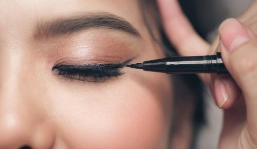 close-up of a woman applying eyeliner